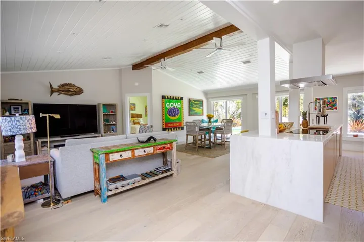 Living area featuring light wood finished floors, a ceiling fan, and wood ceiling