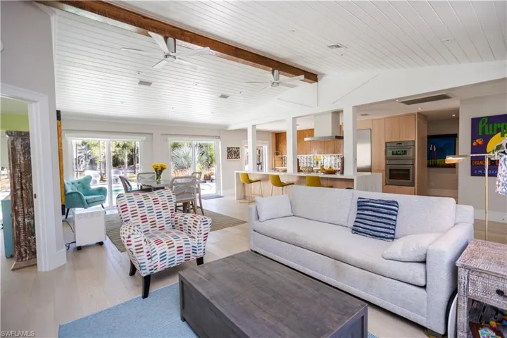 Living room with wood ceiling, light wood finished floors, a ceiling fan, and baseboards