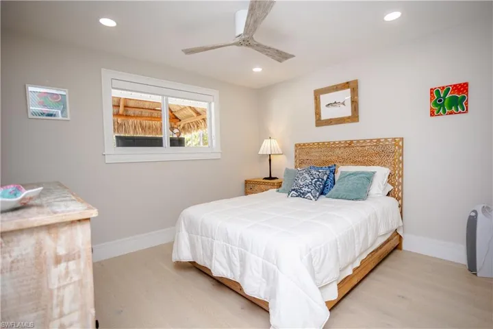 Bedroom with wood finished floors, baseboards, recessed lighting, and ceiling fan