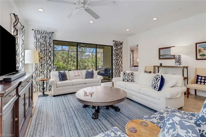 Tiled living room featuring ceiling fan and crown molding