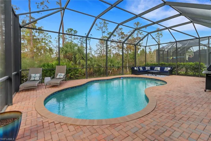 View of swimming pool featuring a lanai, a patio area, and an outdoor hangout area