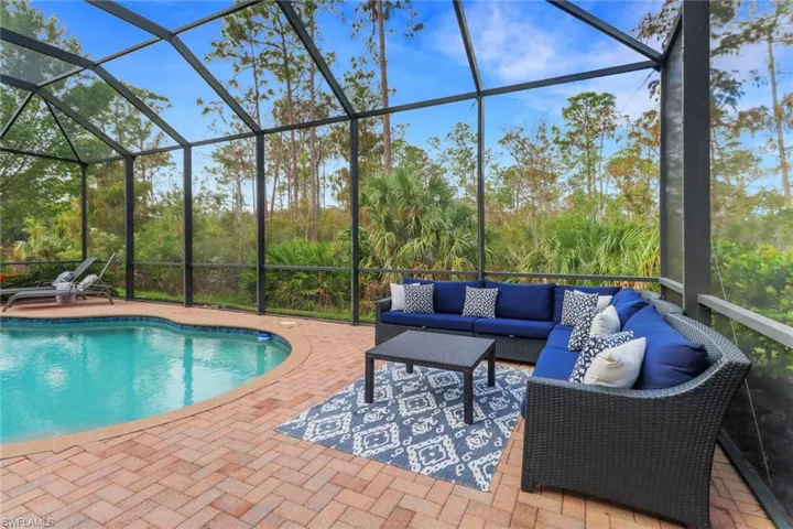 View of pool with a patio area, glass enclosure, and an outdoor hangout area