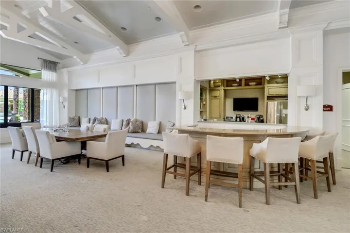 Carpeted dining space featuring beamed ceiling