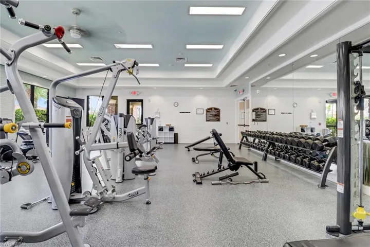 Workout area with a raised ceiling and ceiling fan