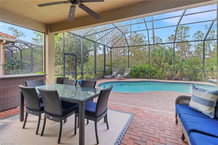 View of swimming pool featuring a lanai, ceiling fan, and a patio area
