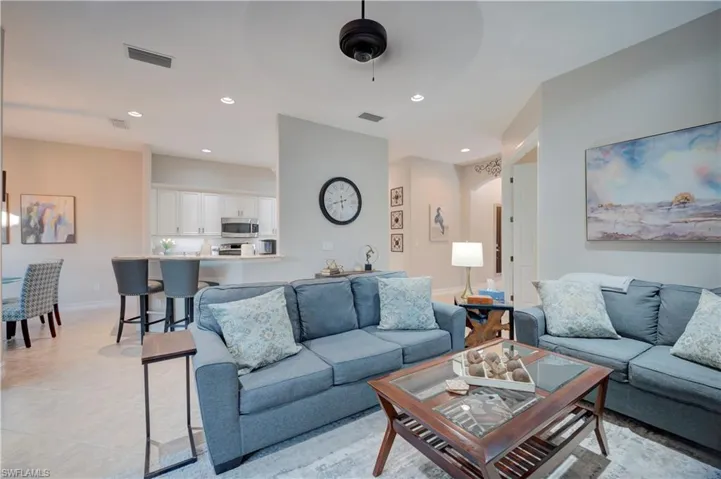 Living area featuring recessed lighting, ceiling fan, light tile patterned floors, and arched walkways