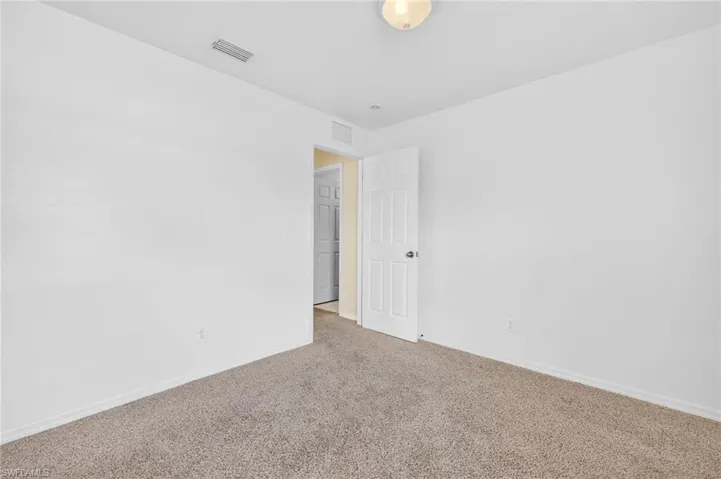 Empty room featuring carpet flooring and baseboards