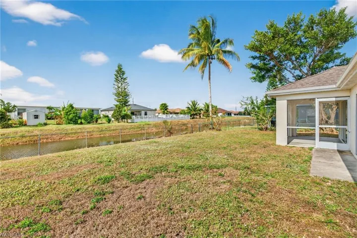 Fenced backyard with a water view and a sunroom