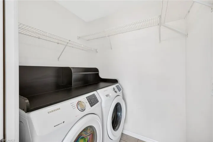 Laundry room with washer and dryer and light tile patterned flooring