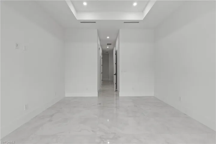 Unfurnished room with a tray ceiling and recessed lighting