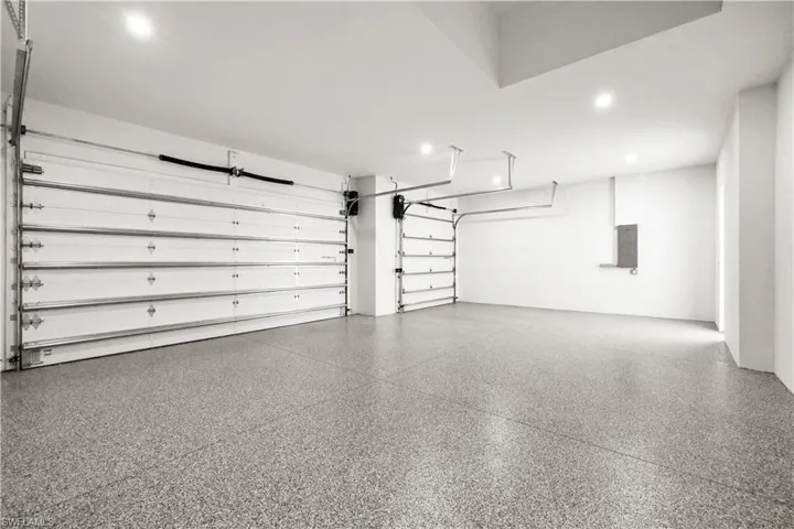 Garage with electric panel and recessed lighting