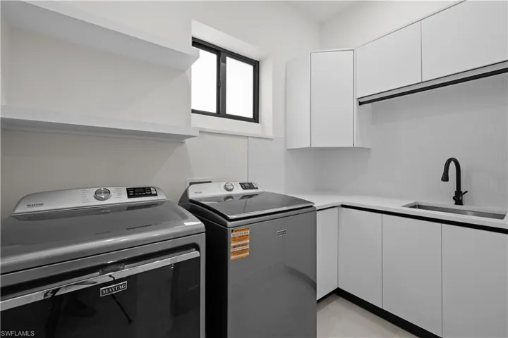 Laundry area featuring cabinet space and washer and clothes dryer