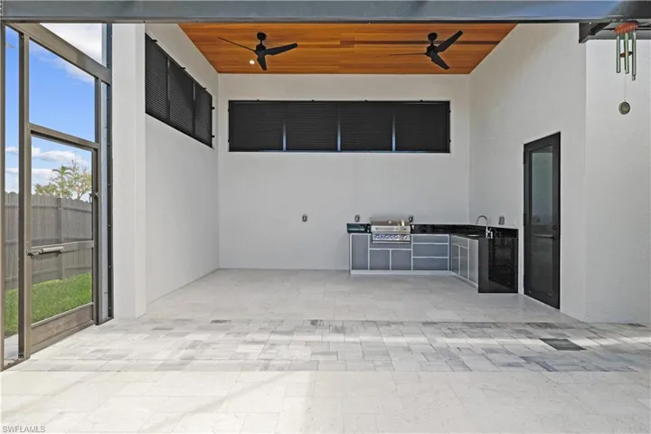 View of patio featuring a ceiling fan and exterior kitchen