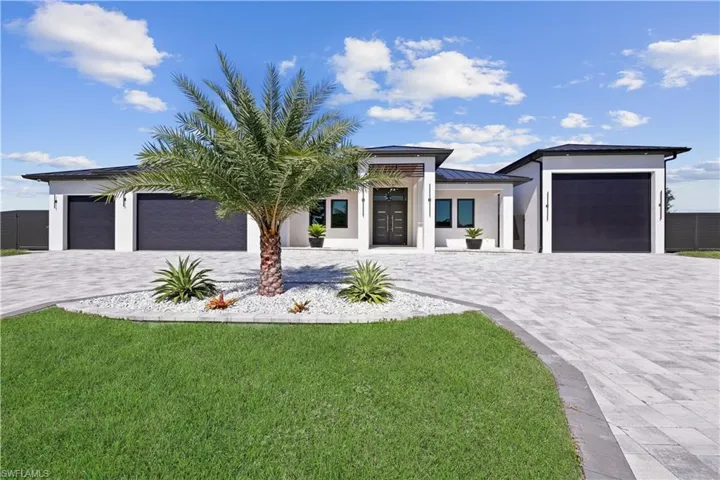 View of front of property with decorative driveway, stucco siding, and a garage