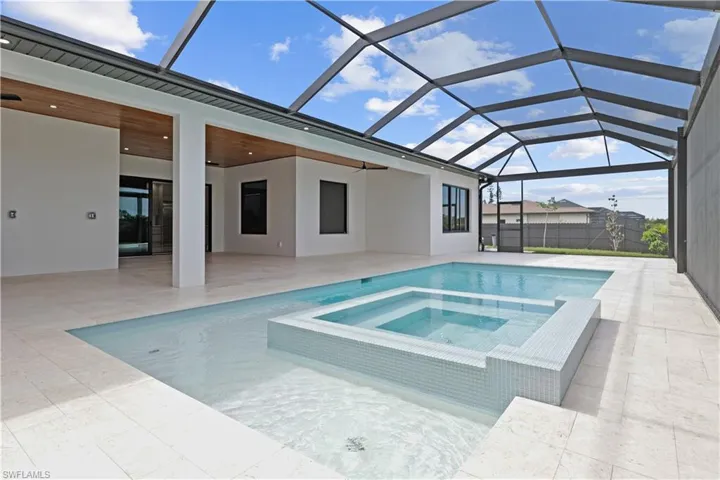 View of pool with a pool with connected hot tub, a sunroom, a lanai, and a patio area