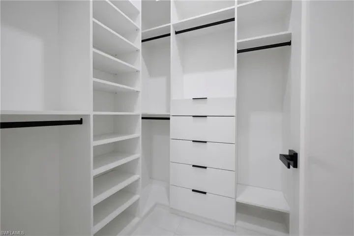 Spacious closet with light tile patterned floors