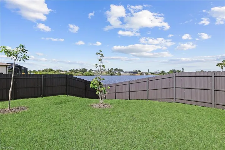 Fenced backyard featuring a water view