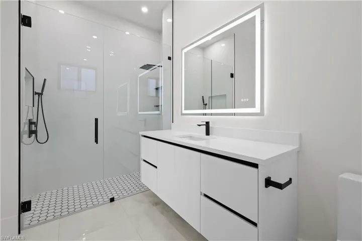Bathroom featuring vanity, a shower stall, and light tile patterned floors