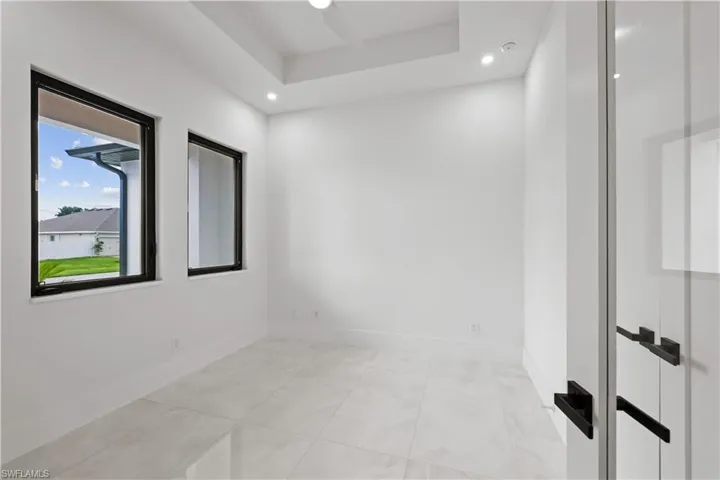 Spare room featuring light tile patterned floors, recessed lighting, and a raised ceiling
