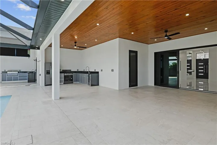 View of patio featuring a ceiling fan, a lanai, and exterior kitchen