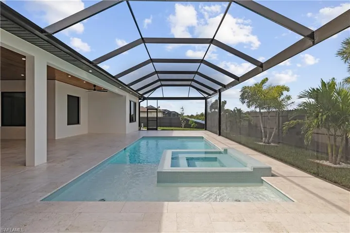 View of pool featuring a pool with connected hot tub, a fenced backyard, a sunroom, and a patio