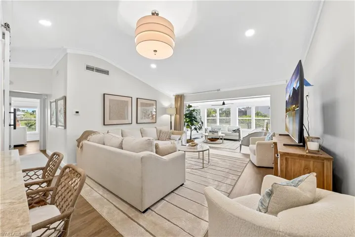 Spacious living area featuring high vaulted ceilings, recessed lighting, and wood-finish flooring