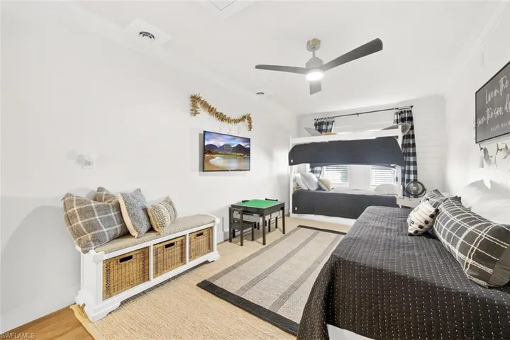 Room featuring a ceiling fan with integrated lighting, wood-finish flooring, and white painted walls