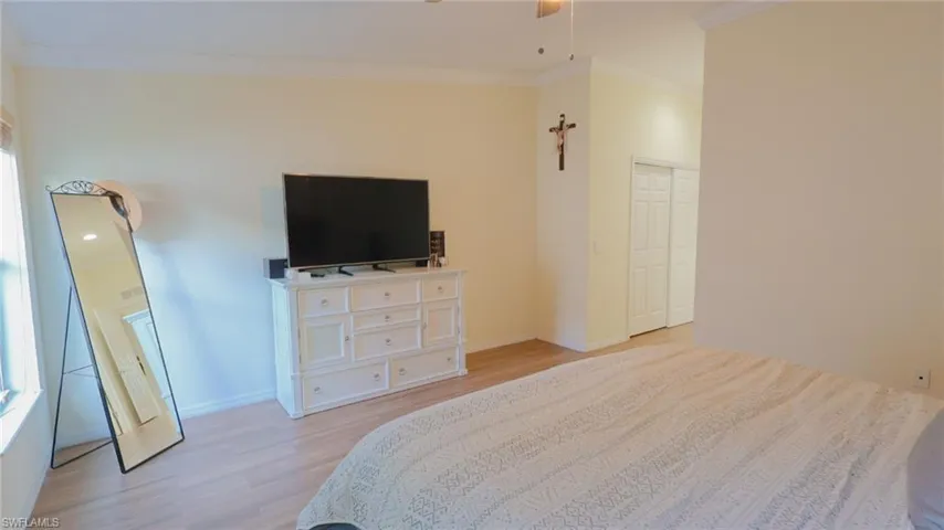 Master Bedroom with baseboards, crown molding, a closet, and light wood-type flooring
