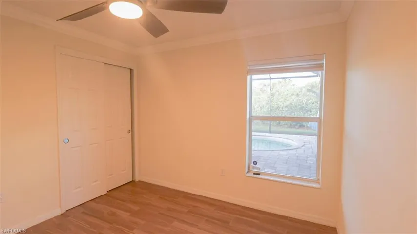 Bedroom 4 with crown molding, baseboards, and light wood-type flooring