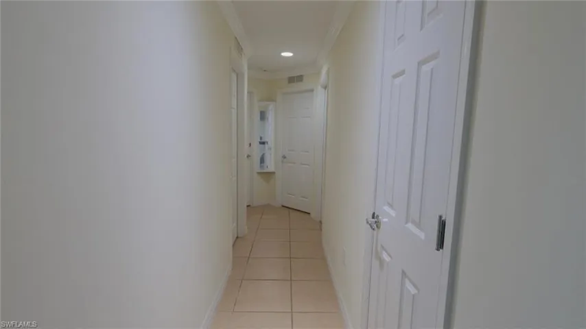 Corridor featuring recessed lighting, ornamental molding, baseboards, light tile patterned flooring, and visible vents