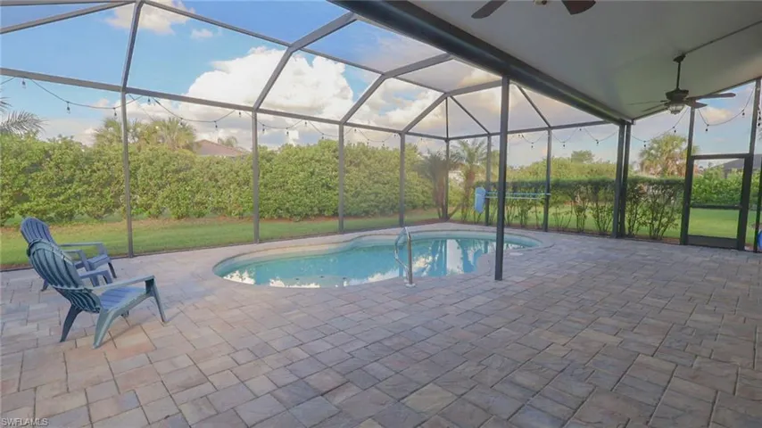 Outdoor pool featuring a patio, ceiling fan, and a lanai