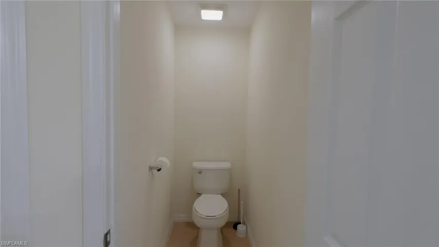 Master Bathroom with baseboards, toilet, and tile patterned flooring