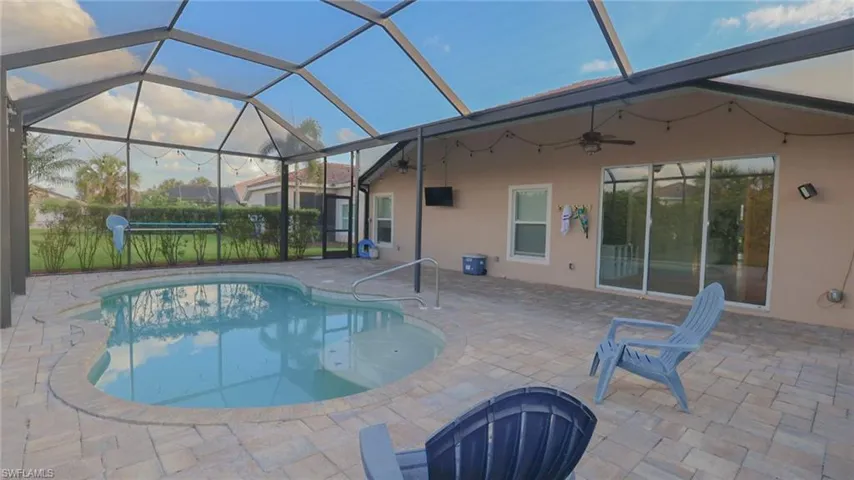 View of swimming pool featuring a ceiling fan, a fenced in pool, glass enclosure, and a patio area