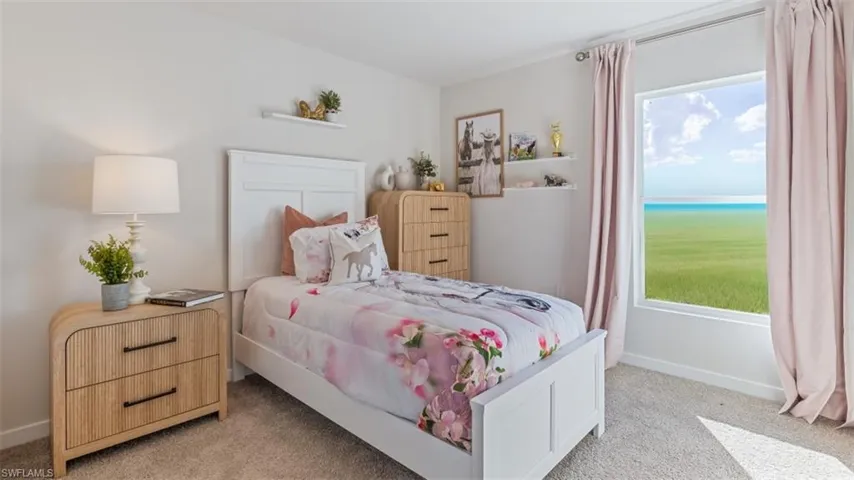 Model home. Bedroom with light carpet and a water view
