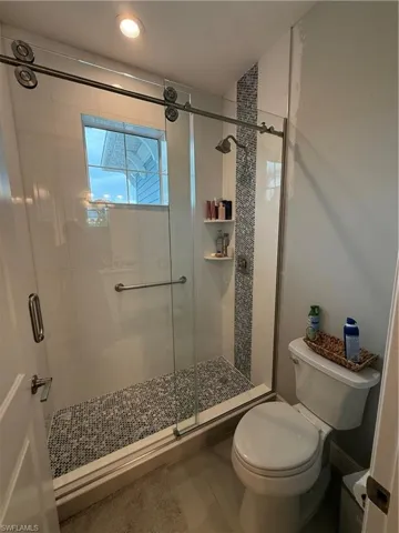 Full bath featuring a stall shower and tile patterned flooring