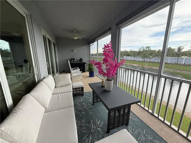 Balcony featuring an outdoor living space, a water view, and a ceiling fan