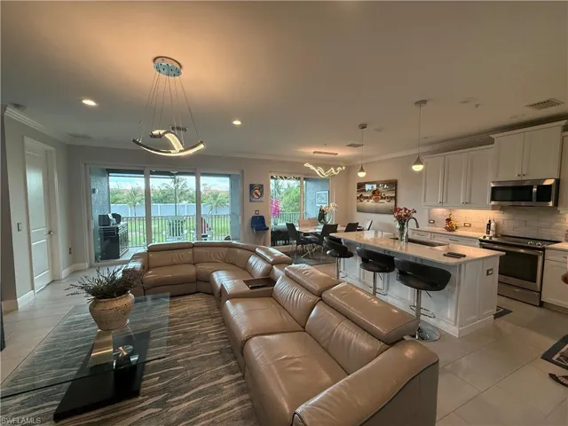 Living room featuring light tile patterned floors, crown molding, and recessed lighting