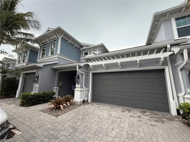 Italianate house featuring a garage, decorative driveway, and stucco siding