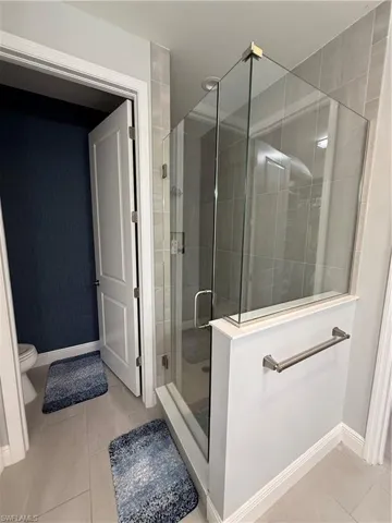 Bathroom featuring tile patterned flooring and a shower stall