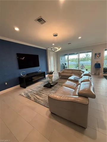 Living room with ornamental molding, recessed lighting, and tile patterned floors