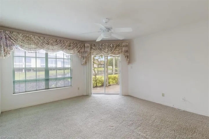 Carpeted spare room with ceiling fan
