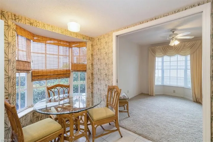 Dining space with a textured ceiling, a healthy amount of sunlight, ceiling fan, and light carpet