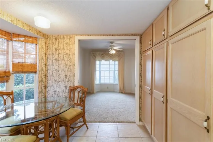 Carpeted dining room with a textured ceiling and ceiling fan