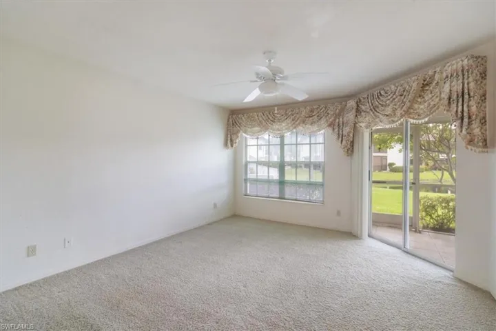Carpeted empty room with ceiling fan