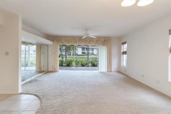 Unfurnished living room with ceiling fan and light colored carpet