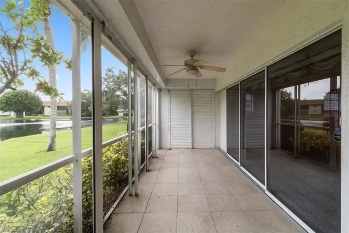 Unfurnished sunroom with ceiling fan and a water view