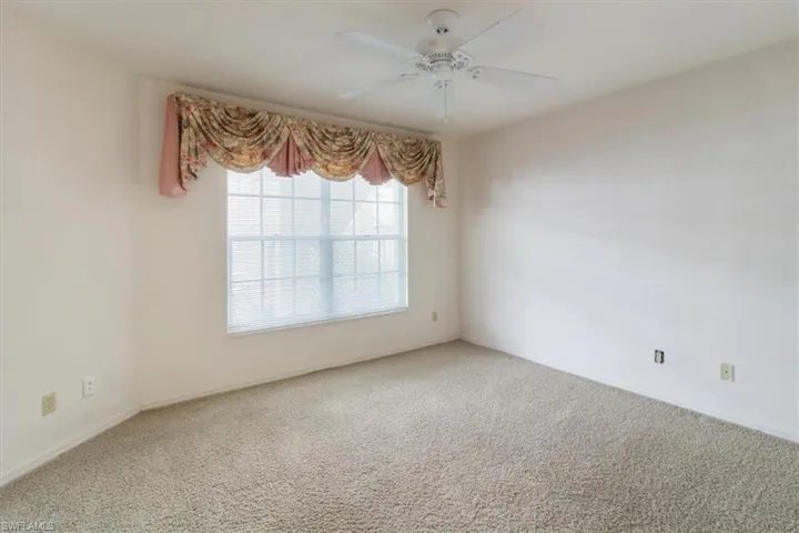 Empty room with ceiling fan and carpet floors