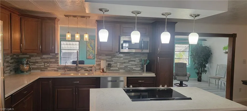 Kitchen featuring pendant lighting, decorative backsplash, and stainless steel appliances