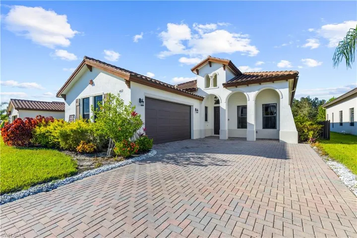 Mediterranean / spanish home with cooling unit and a garage