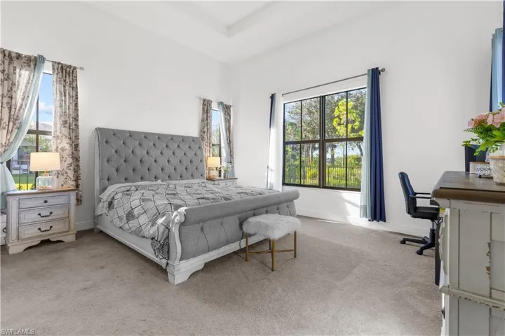 Carpeted bedroom featuring multiple windows